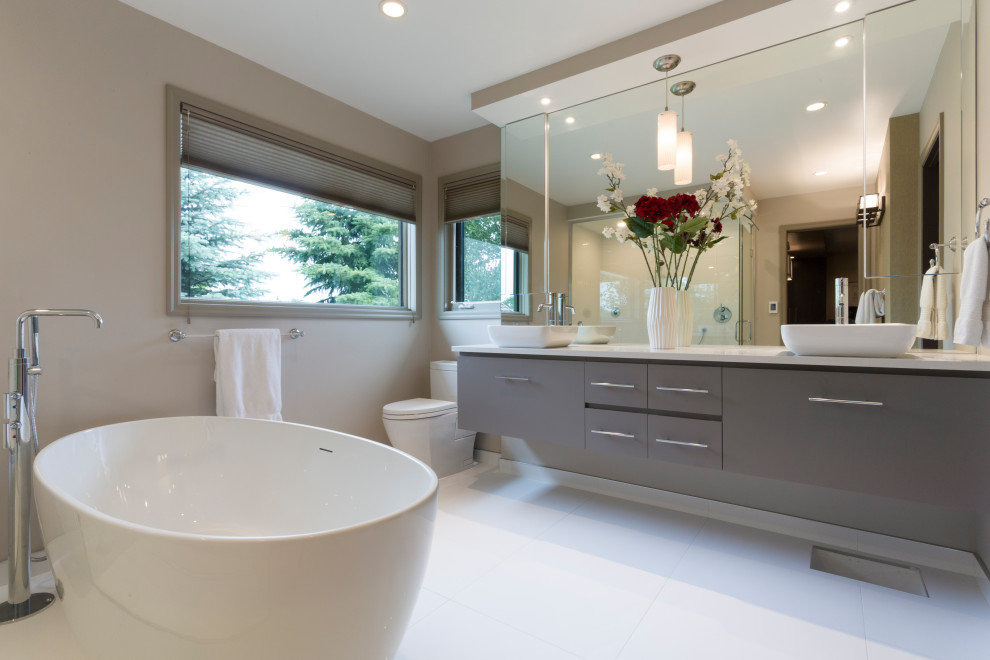 Large modern bathroom in Other with furniture-like cabinets, brown cabinets, a freestanding tub, a corner shower, a bidet, white tile, brown walls, a vessel sink, granite benchtops, a hinged shower door, white benchtops, a double vanity and a floating vanity.