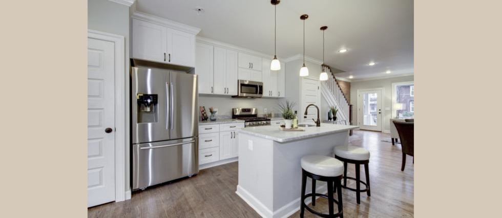 Mid-sized transitional galley medium tone wood floor eat-in kitchen photo in DC Metro with an undermount sink, shaker cabinets, white cabinets, marble countertops, gray backsplash, stainless steel appliances and an island