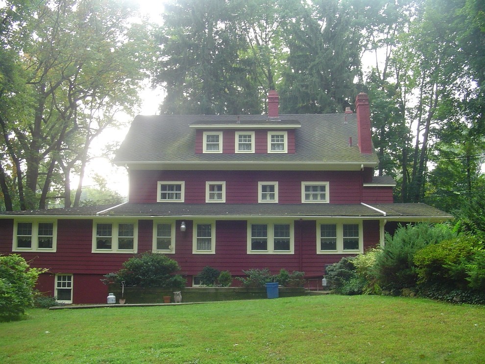 Country two-storey red exterior in New York with wood siding.