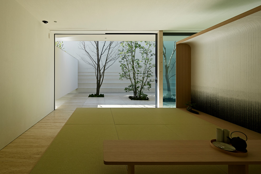 This is an example of a modern family room in Tokyo with white walls, travertine floors, no tv and beige floor.
