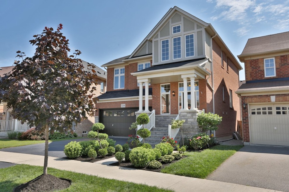 Large arts and crafts two-storey brick red exterior in Toronto.
