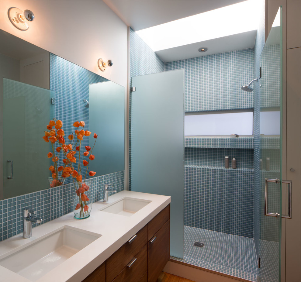 Inspiration for a mid-sized contemporary master bathroom in San Francisco with an undermount sink, flat-panel cabinets, dark wood cabinets, engineered quartz benchtops, an alcove shower, a one-piece toilet, blue tile, glass tile, white walls and medium hardwood floors.