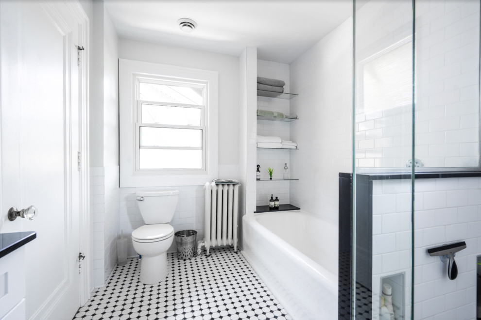 Photo of a mid-sized traditional master bathroom in Other with shaker cabinets, white cabinets, an alcove tub, a corner shower, a two-piece toilet, white tile, ceramic tile, green walls, mosaic tile floors, an undermount sink, engineered quartz benchtops, multi-coloured floor, a hinged shower door and black benchtops.