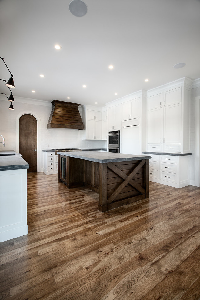 Inspiration for a large transitional u-shaped eat-in kitchen remodel in Calgary with shaker cabinets, paneled appliances and an island