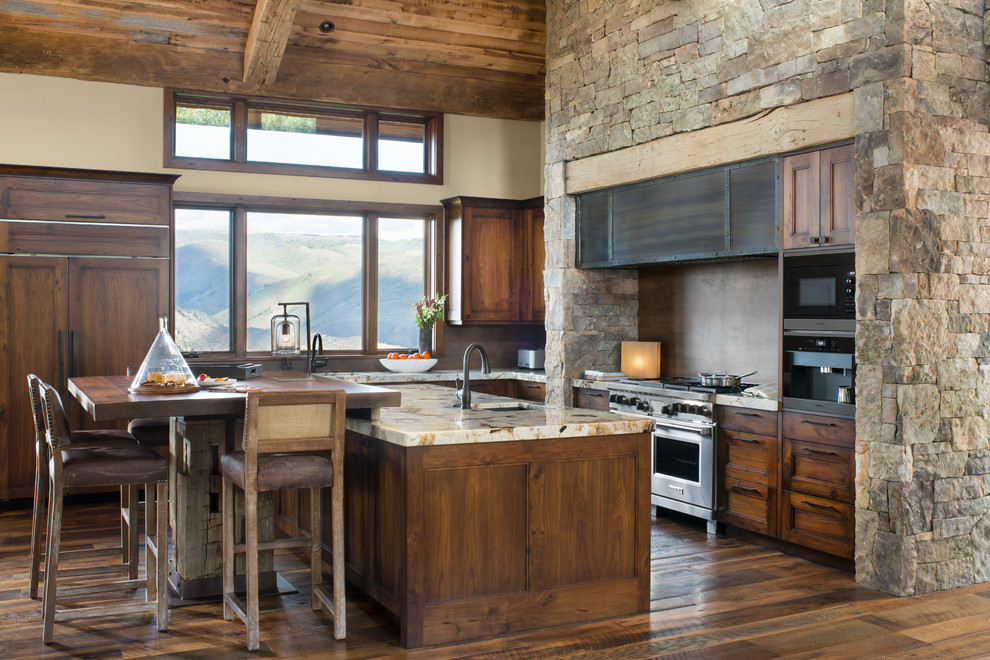 Photo of a large country l-shaped kitchen in Denver with shaker cabinets, dark wood cabinets, granite benchtops, panelled appliances, dark hardwood floors, with island and brown floor.