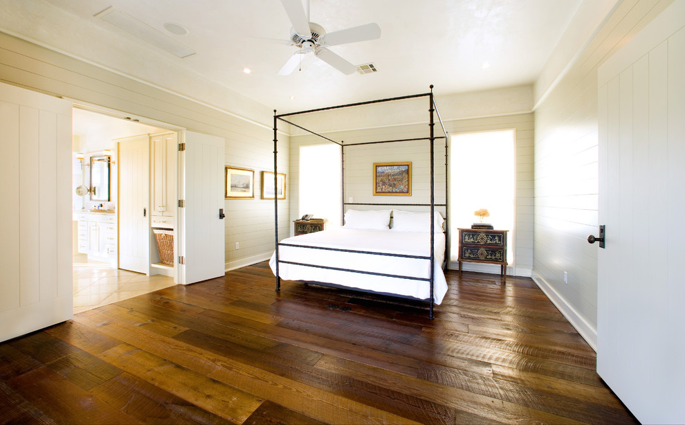 Large country master bedroom in Austin with beige walls, dark hardwood floors, no fireplace and brown floor.