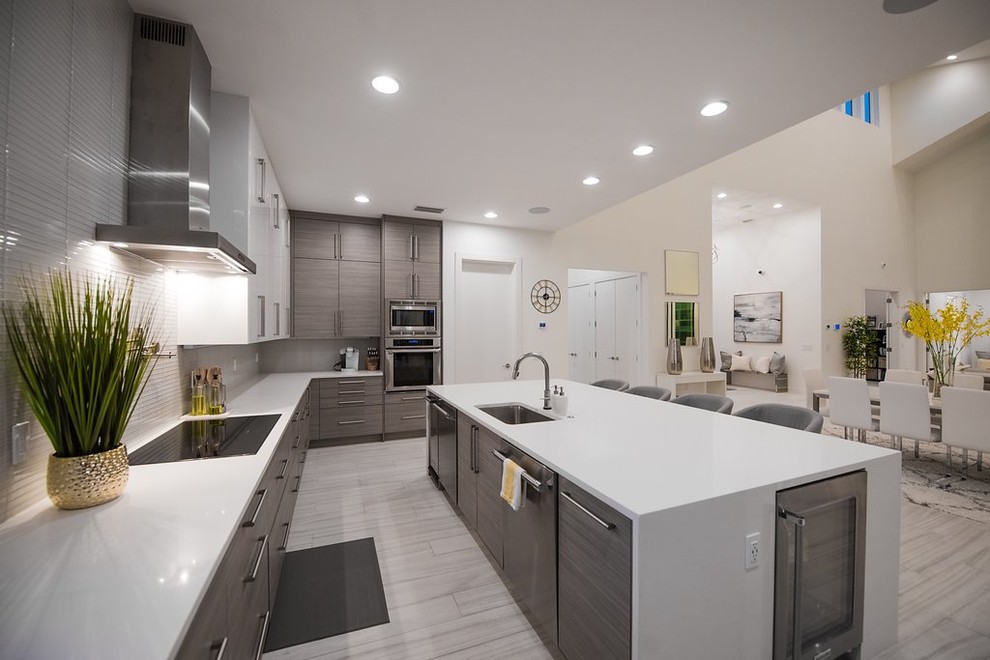 Inspiration for a contemporary kitchen in Tampa with an undermount sink, flat-panel cabinets, white splashback, stainless steel appliances, with island and white benchtop.