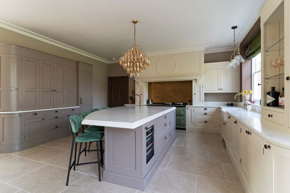 This is an example of a large traditional l-shaped eat-in kitchen in Oxfordshire with an undermount sink, shaker cabinets, beige cabinets, quartzite benchtops, brown splashback, ceramic floors, with island, beige floor and white benchtop.