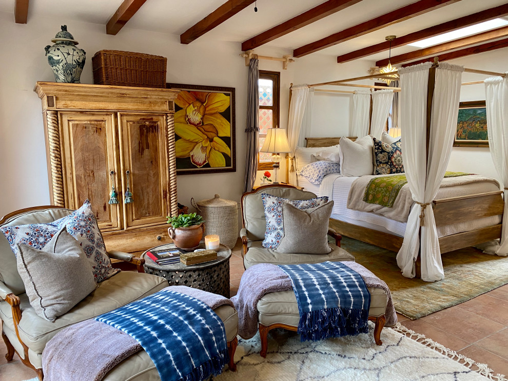 Photo of a medium sized beach style guest bedroom in Other with white walls, terracotta flooring, a corner fireplace, a plastered fireplace surround, orange floors and exposed beams.