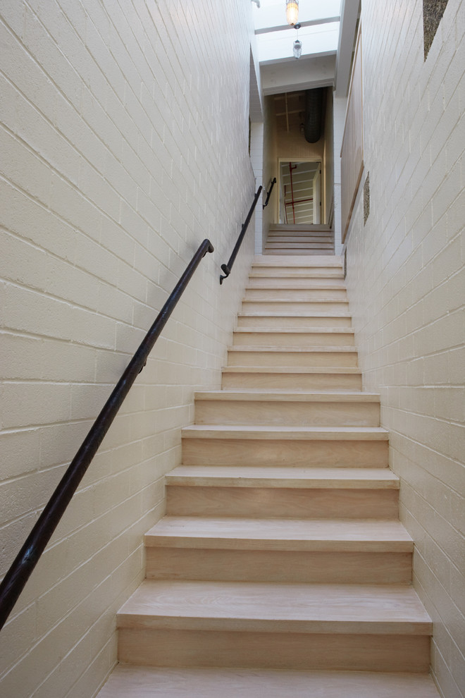 Inspiration for a mid-sized industrial wood straight staircase in Orange County with wood risers.