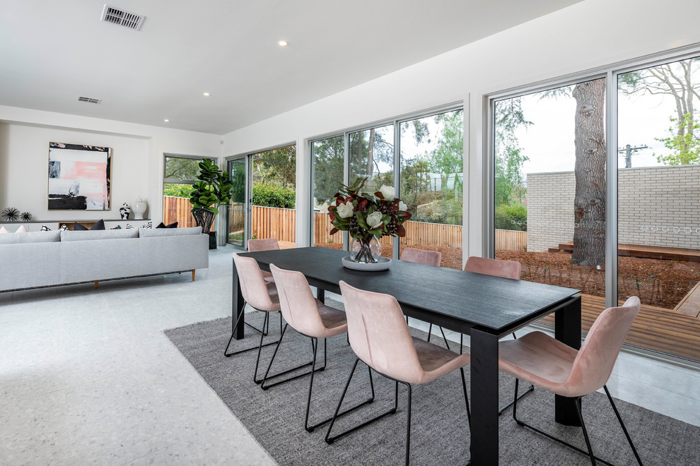 Photo of a contemporary dining room in Canberra - Queanbeyan with white walls and grey floor.