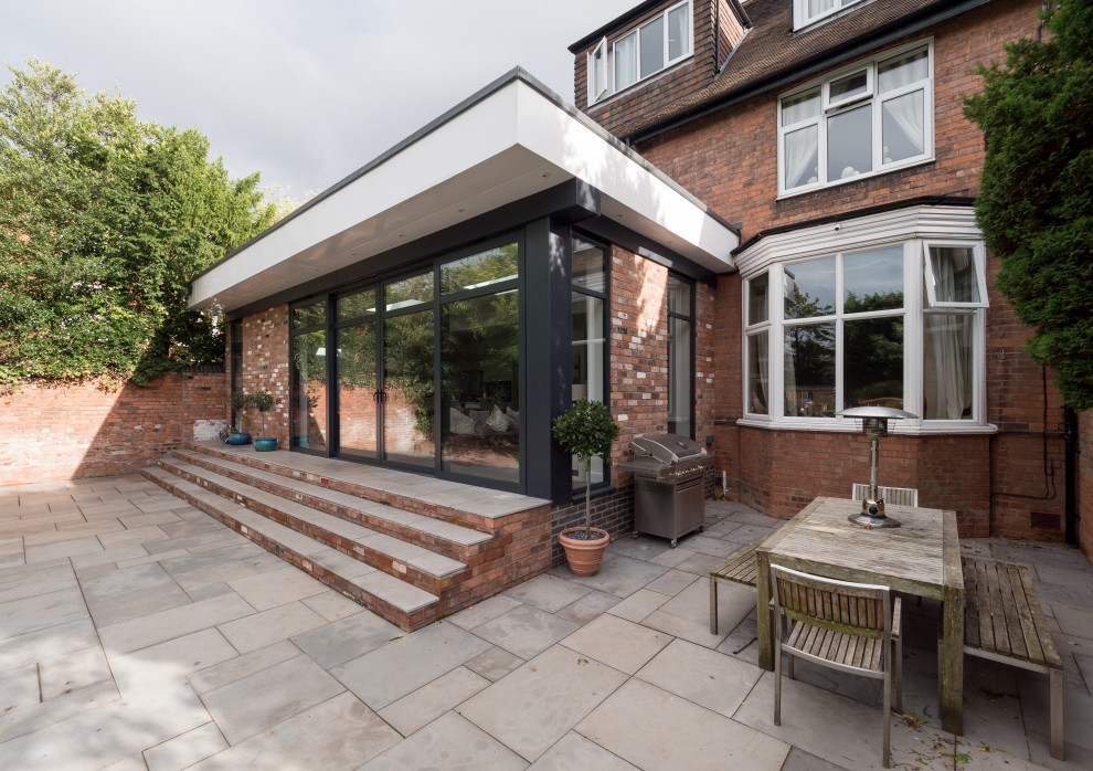 This is an example of a mid-sized contemporary one-storey brick duplex exterior in West Midlands with a flat roof.
