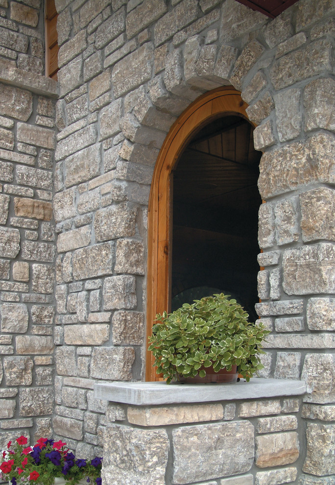 Large mountain style one-story stone gray home design photo in Chicago
