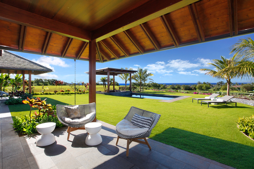 Inspiration for a mid-sized tropical backyard verandah in Hawaii with a roof extension.