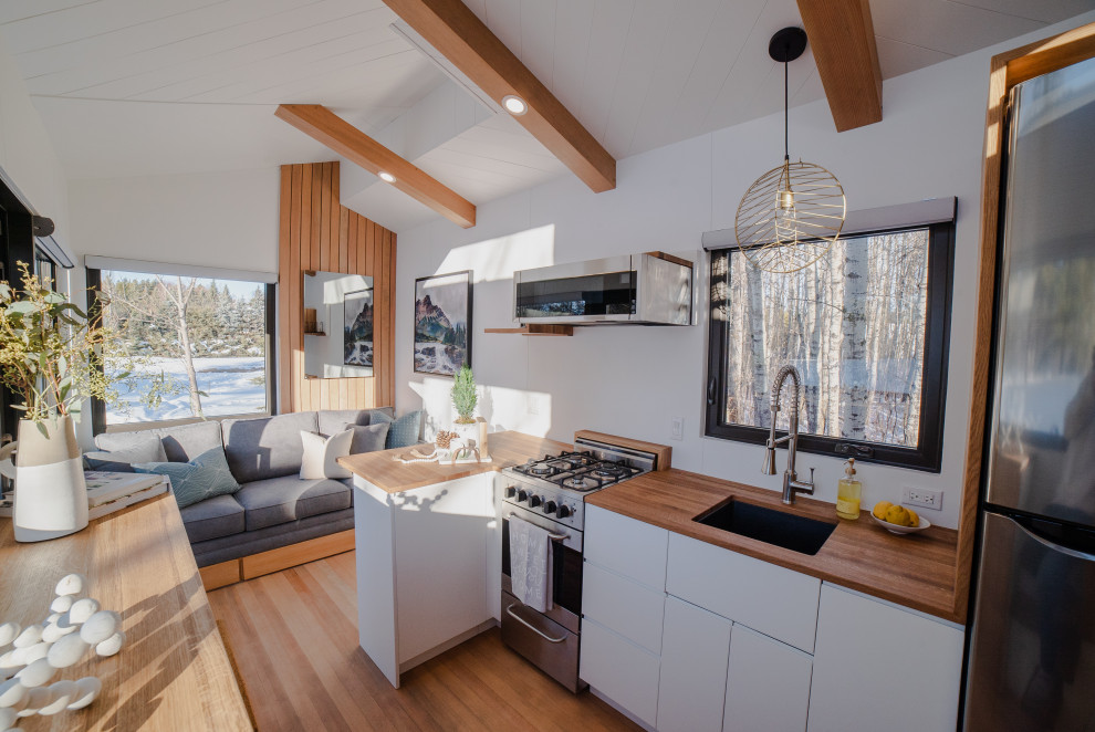 Стильный дизайн: кухня в скандинавском стиле с деревянной столешницей и светлым паркетным полом - последний тренд