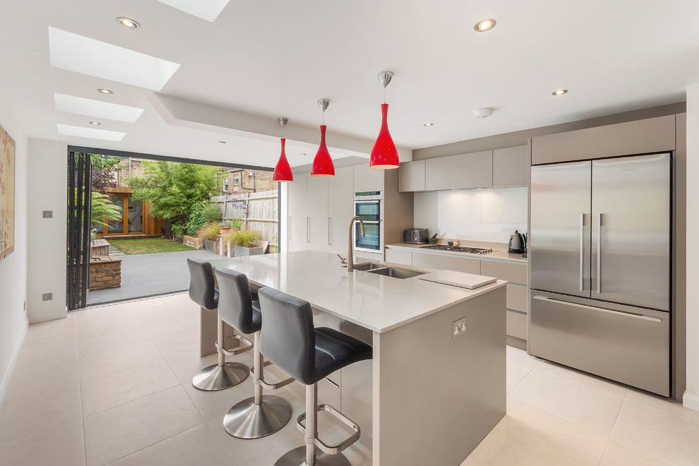 Inspiration for a large contemporary u-shaped separate kitchen in London with an undermount sink, flat-panel cabinets, grey cabinets, white splashback, stainless steel appliances and a peninsula.