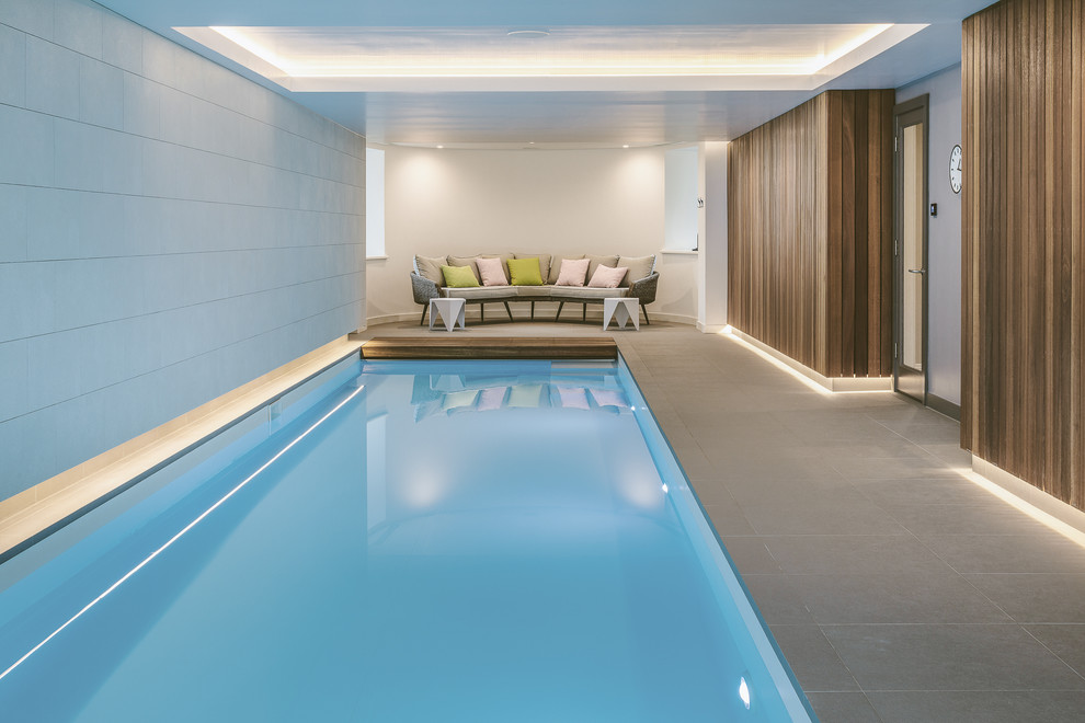 Photo of a contemporary indoor rectangular lap pool in Other with tile.