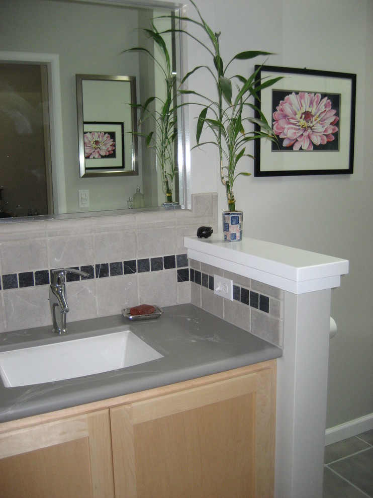 This is an example of a contemporary bathroom in San Francisco with shaker cabinets and solid surface benchtops.