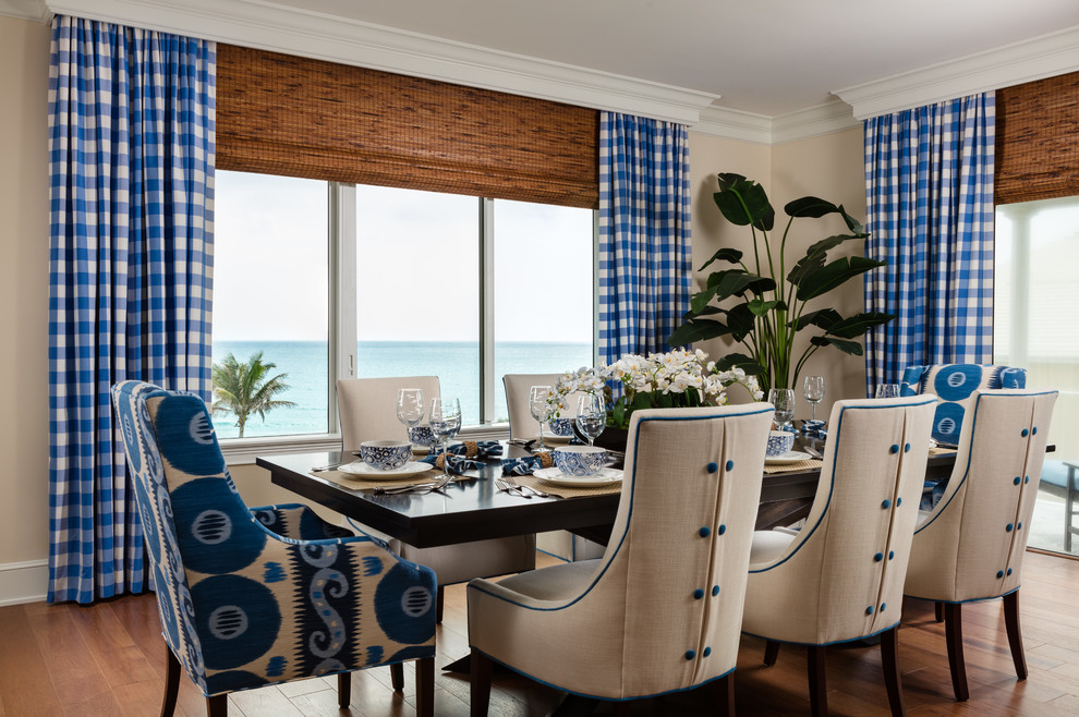 Inspiration for a mid-sized beach style separate dining room in Miami with white walls, medium hardwood floors, brown floor and no fireplace.