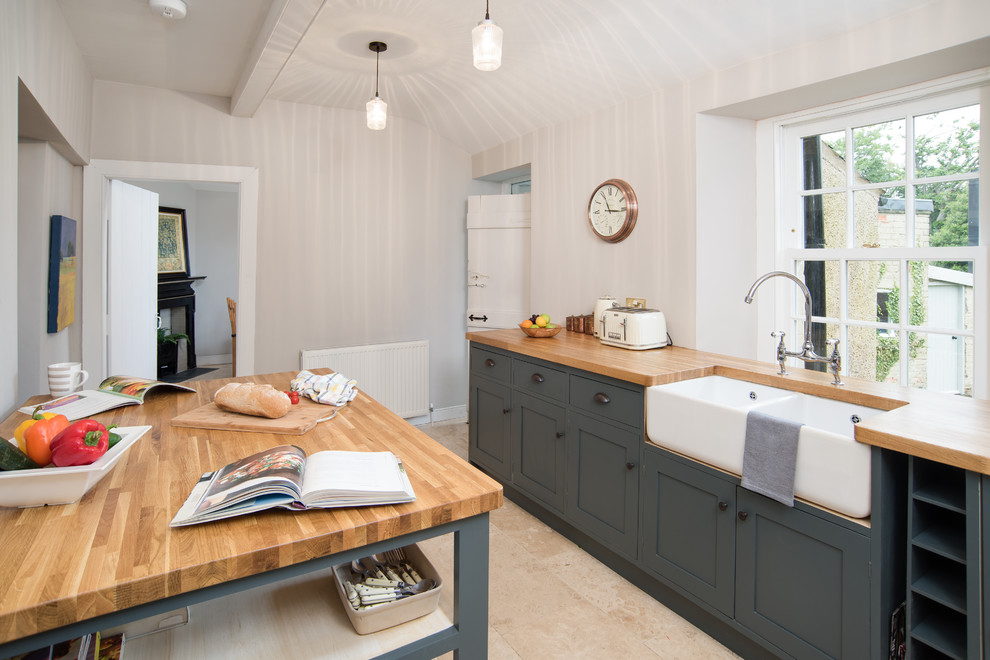Mid-sized country single-wall separate kitchen in Other with a farmhouse sink, shaker cabinets, blue cabinets, wood benchtops, white appliances, terra-cotta floors, with island and beige floor.
