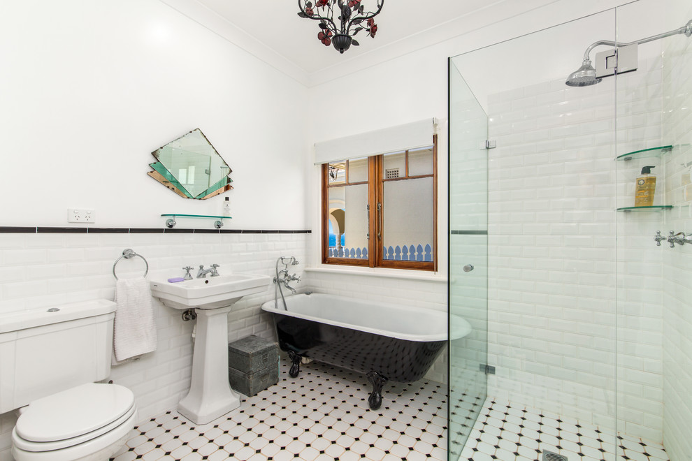 Mid-sized traditional master bathroom in Sydney with a claw-foot tub, a corner shower, a two-piece toilet, black and white tile, ceramic tile, white walls, ceramic floors and a pedestal sink.