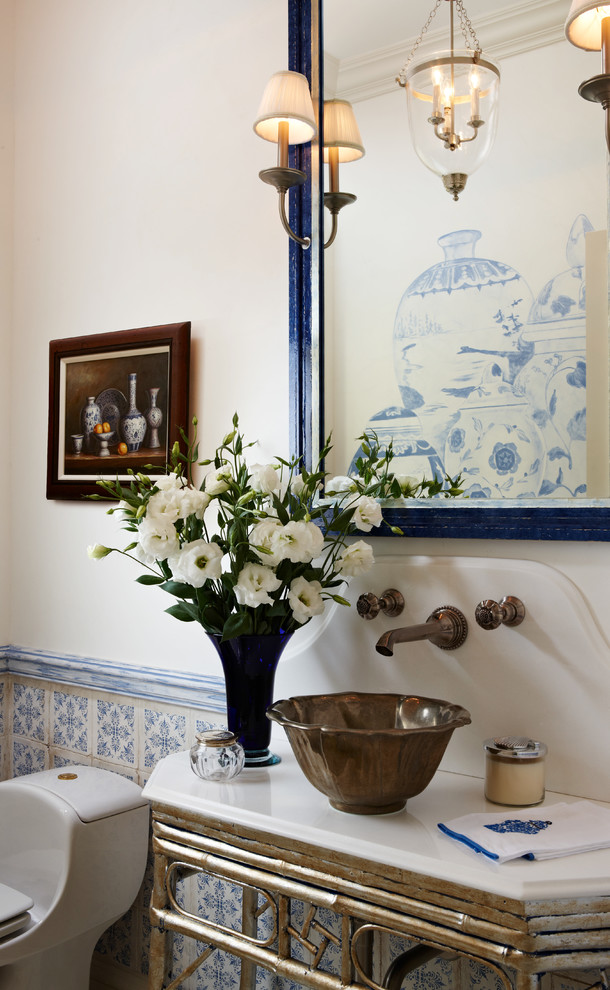 This is an example of a traditional powder room in Miami with a vessel sink and furniture-like cabinets.