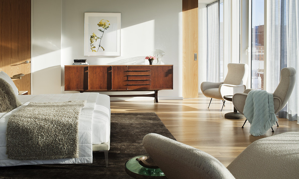 Bedroom - mid-century modern light wood floor bedroom idea in New York with white walls