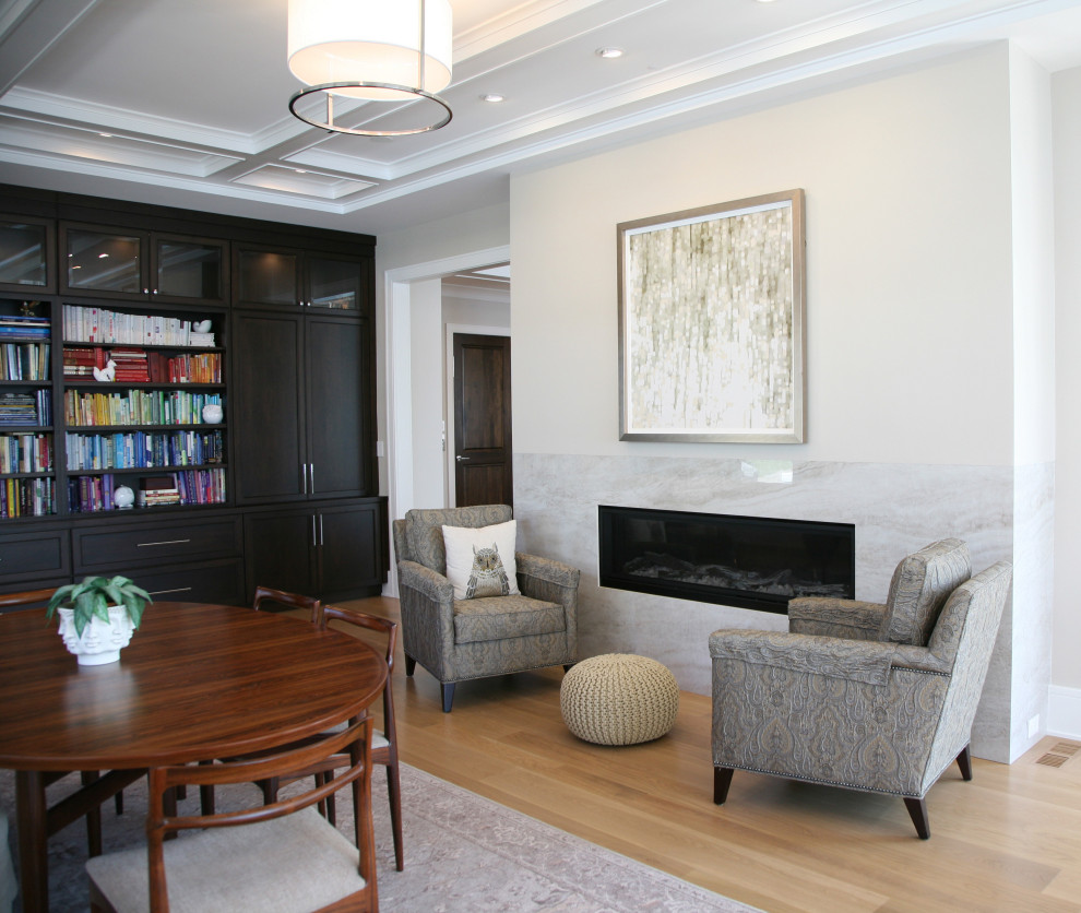 Inspiration for a large contemporary open concept family room in Milwaukee with a library, beige walls, light hardwood floors, a two-sided fireplace, a stone fireplace surround, no tv, brown floor and coffered.