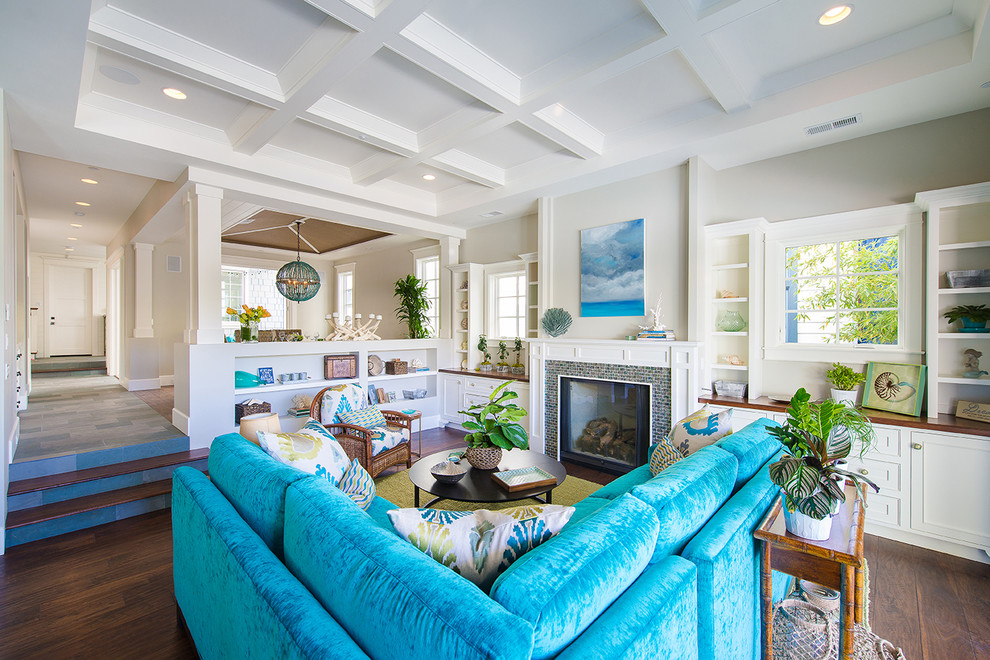 Inspiration for a large beach style open concept family room in Los Angeles with a standard fireplace, a tile fireplace surround, no tv, grey walls, dark hardwood floors and brown floor.