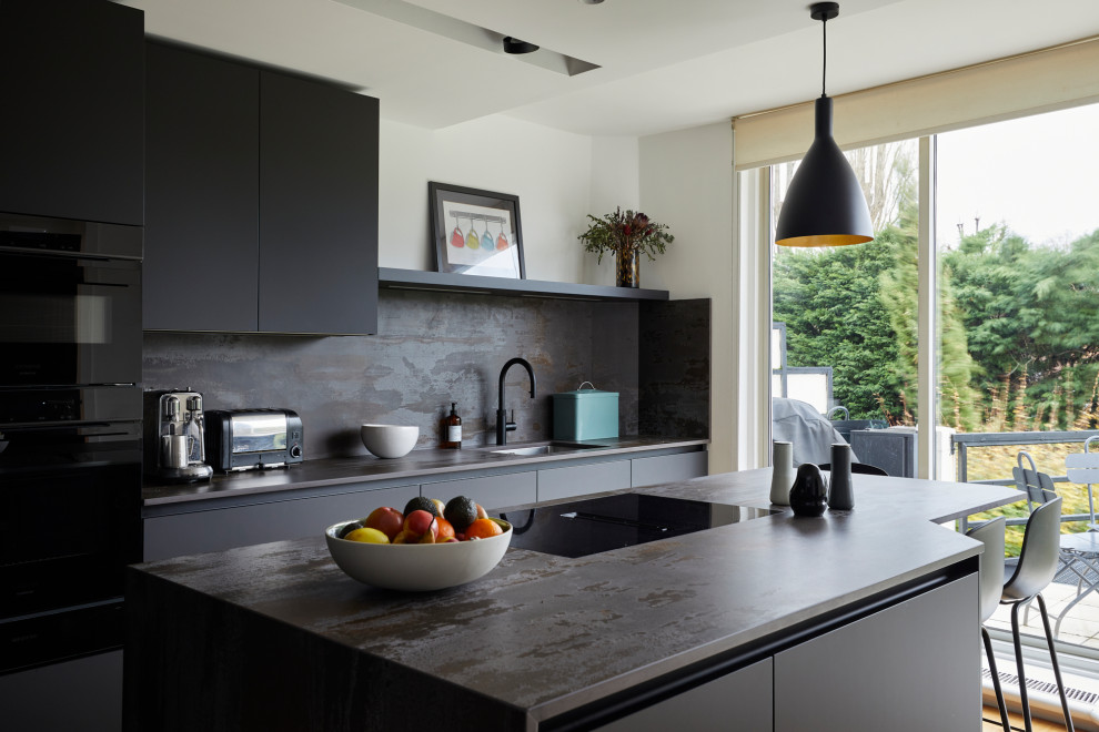 Inspiration for a small modern l-shaped separate kitchen in London with an undermount sink, flat-panel cabinets, quartz benchtops, multi-coloured splashback, engineered quartz splashback, black appliances, light hardwood floors, with island and multi-coloured benchtop.