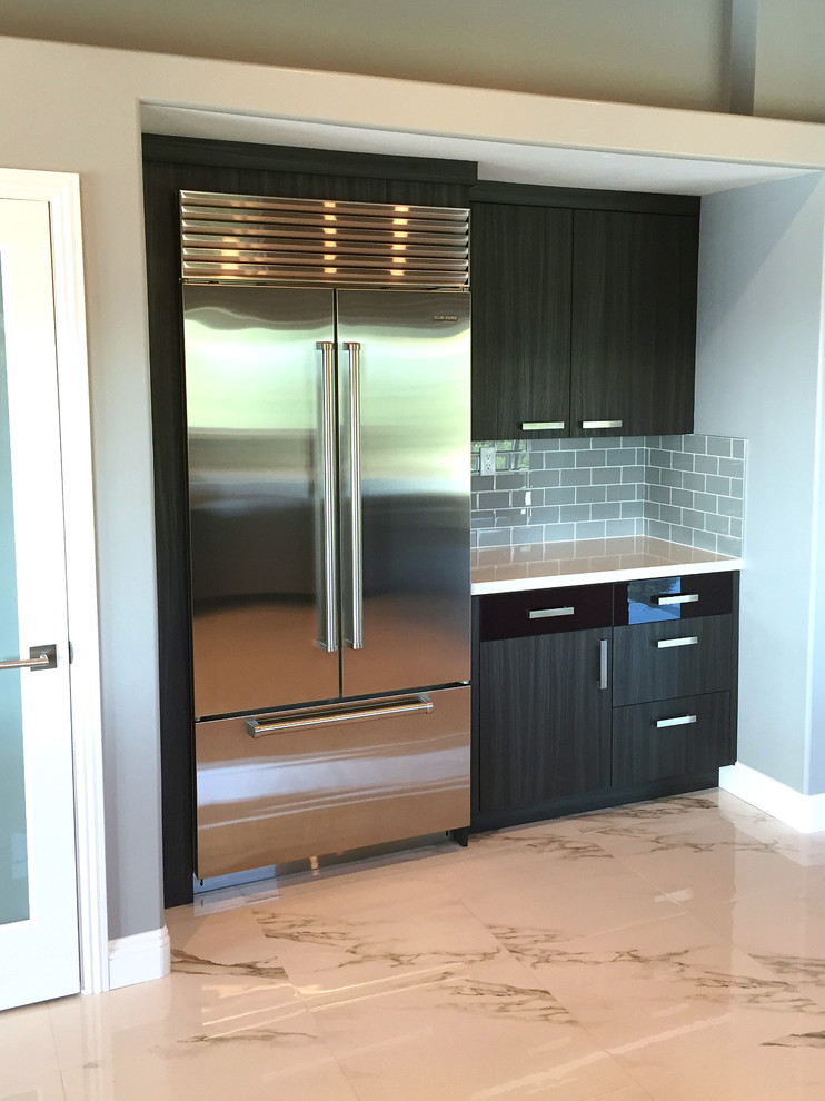 Large modern u-shaped eat-in kitchen in Los Angeles with a farmhouse sink, flat-panel cabinets, dark wood cabinets, quartz benchtops, grey splashback, glass tile splashback, stainless steel appliances and marble floors.