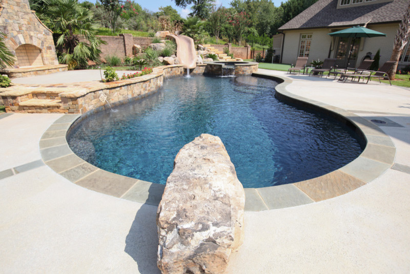 Mid-sized country backyard custom-shaped lap pool in Other with a hot tub and natural stone pavers.
