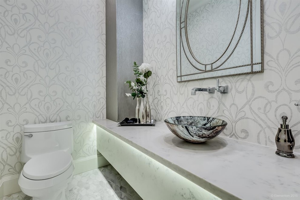 This is an example of a small transitional powder room in Vancouver with a one-piece toilet, white tile, mosaic tile, white walls, marble floors and quartzite benchtops.