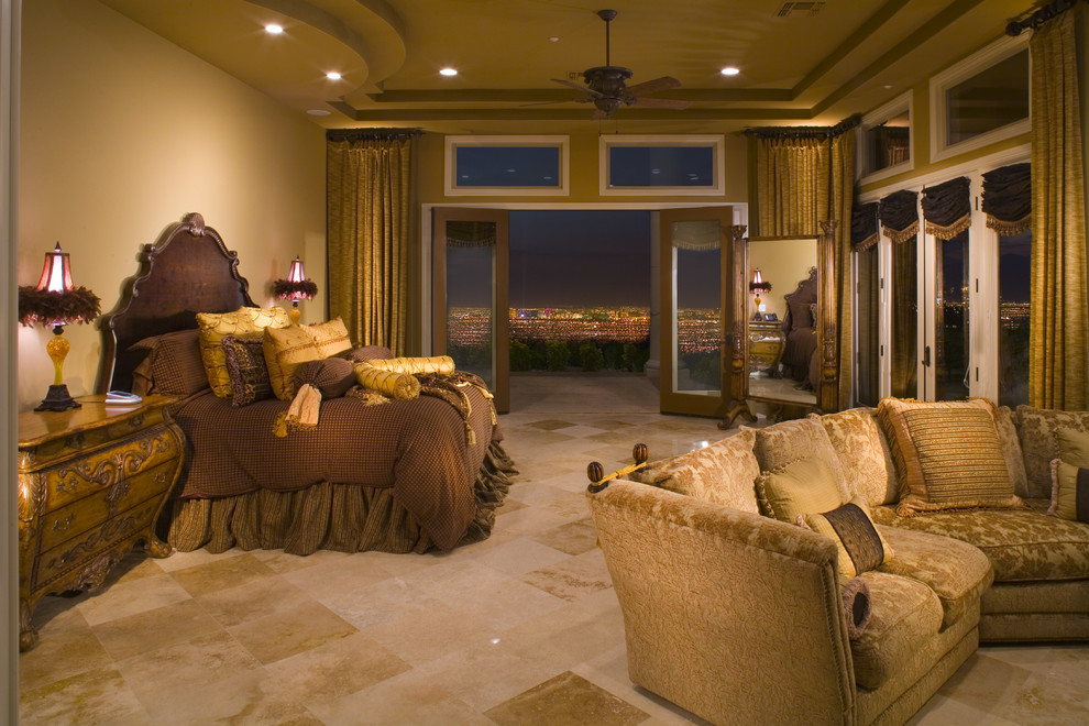 Photo of an expansive mediterranean master bedroom in Las Vegas with beige walls, brick floors, beige floor and vaulted.