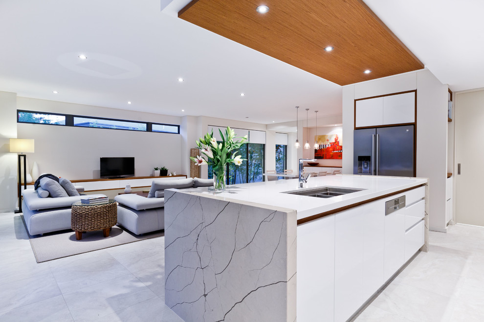 Inspiration for a mid-sized contemporary galley open plan kitchen in Perth with an undermount sink, flat-panel cabinets, white cabinets, quartz benchtops, window splashback, stainless steel appliances, ceramic floors, with island and grey floor.