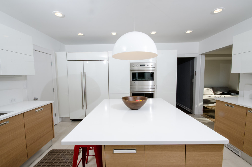 Mid-sized modern u-shaped eat-in kitchen in New York with an undermount sink, flat-panel cabinets, light wood cabinets, solid surface benchtops, white splashback, stainless steel appliances, porcelain floors, with island and beige floor.
