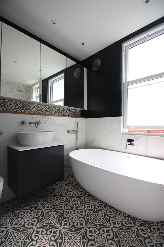 Contemporary bathroom in Sussex with a freestanding tub, an open shower, white walls, ceramic floors, a wall-mount sink and an open shower.