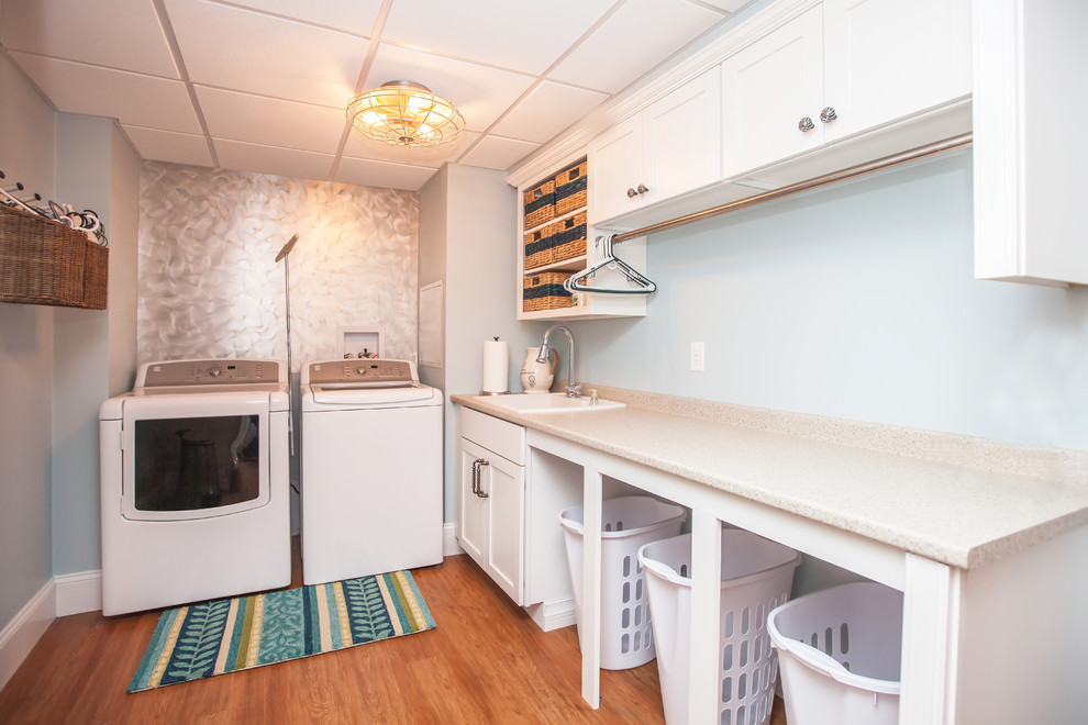 Inspiration for a mid-sized beach style galley dedicated laundry room in Boston with a single-bowl sink, shaker cabinets, white cabinets, laminate benchtops, blue walls, linoleum floors and a side-by-side washer and dryer.