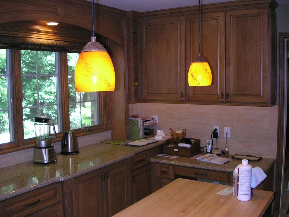 Mid-sized elegant l-shaped eat-in kitchen photo with recessed-panel cabinets, medium tone wood cabinets, granite countertops, beige backsplash, ceramic backsplash, stainless steel appliances and an island