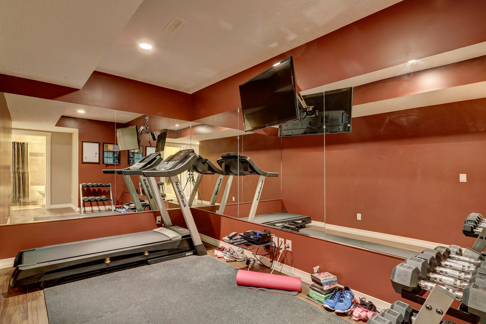This is an example of a small transitional multipurpose gym in Calgary with red walls and medium hardwood floors.