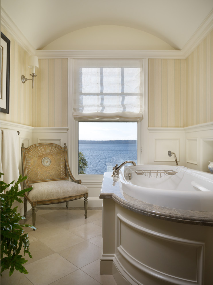 Traditional bathroom in Seattle with recessed-panel cabinets, beige cabinets, a drop-in tub and beige tile.