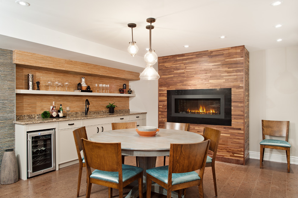 Inspiration for a large transitional fully buried basement in Toronto with grey walls, a ribbon fireplace, cork floors, a metal fireplace surround, brown floor and a home bar.