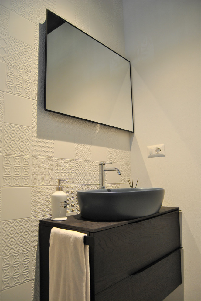 Small cloakroom in Milan with flat-panel cabinets, brown cabinets, a one-piece toilet, white tiles, porcelain tiles, white walls, porcelain flooring, a vessel sink, wooden worktops, grey floors, brown worktops and a floating vanity unit.