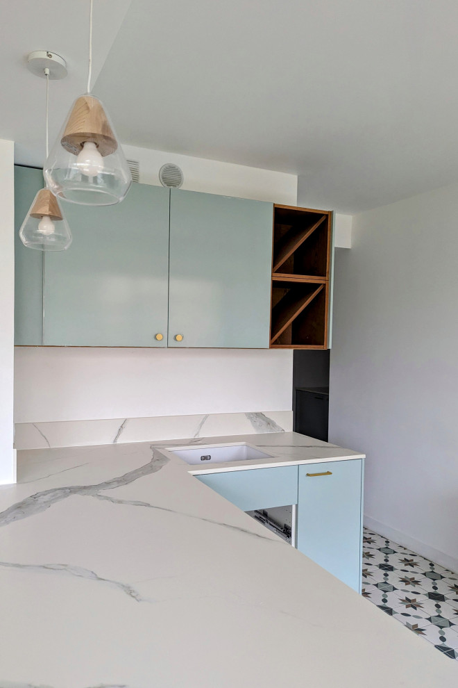 Large contemporary u-shaped open plan kitchen in Paris with a submerged sink, beaded cabinets, green cabinets, composite countertops, white splashback, ceramic splashback, integrated appliances, ceramic flooring, an island, green floors and white worktops.