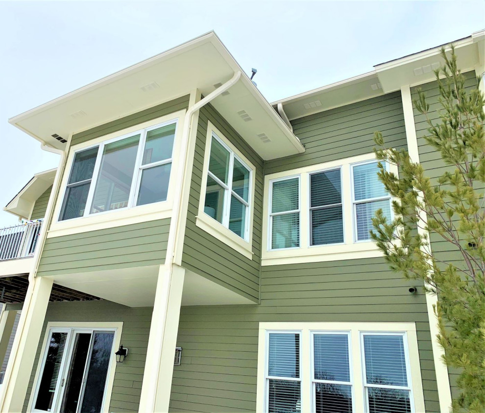 Ispirazione per la facciata di un appartamento grande verde moderno a due piani con copertura a scandole e tetto marrone