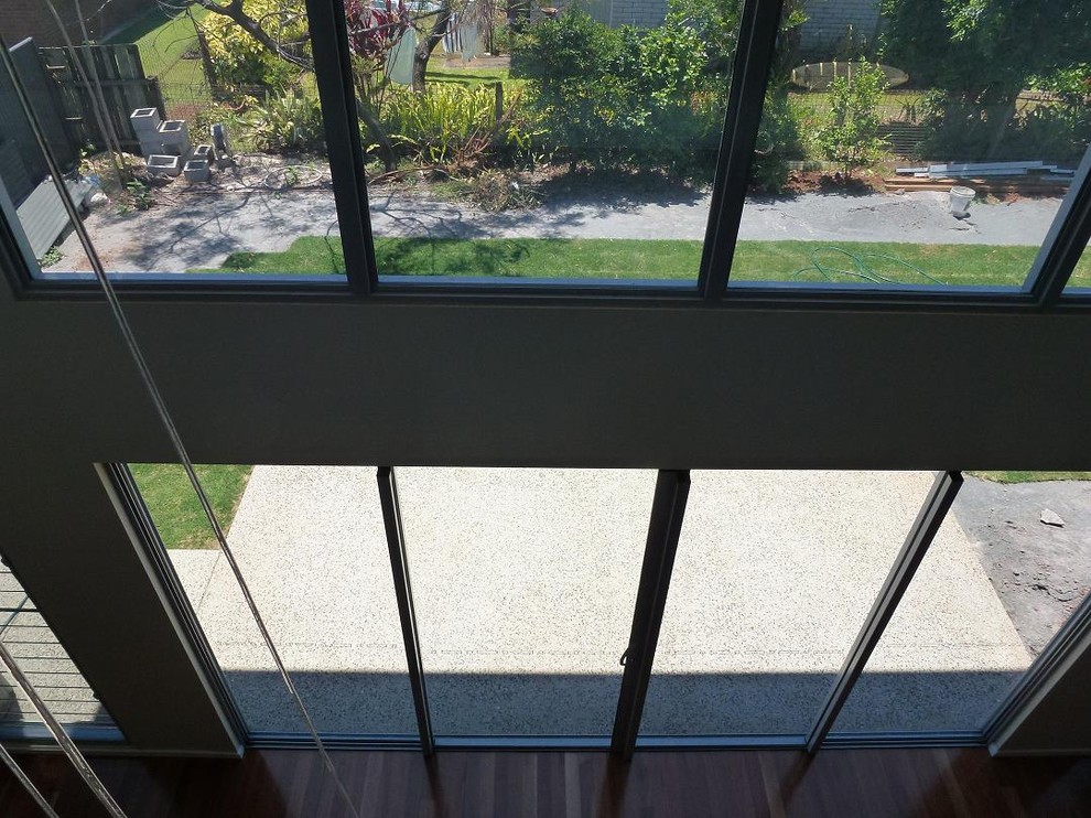 Large contemporary open concept living room in Brisbane with carpet and grey floor.
