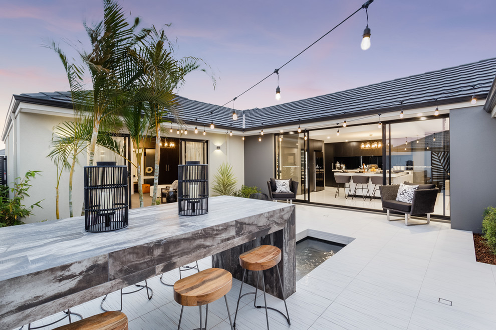 Contemporary backyard patio in Perth with natural stone pavers and no cover.