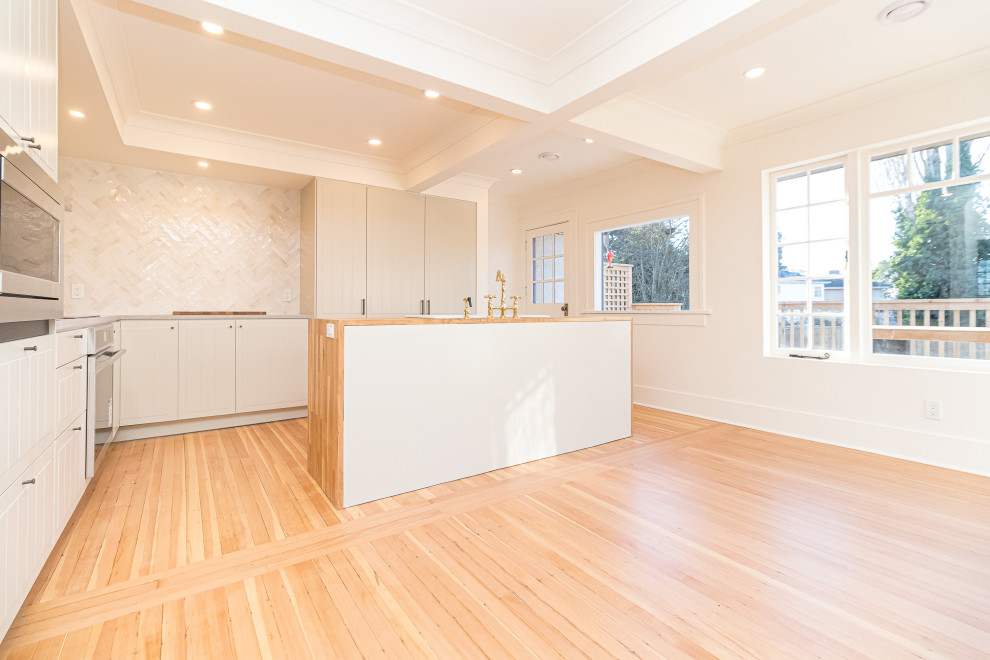 Inspiration for a mid-sized transitional l-shaped medium tone wood floor, brown floor and coffered ceiling eat-in kitchen remodel with a farmhouse sink, raised-panel cabinets, gray cabinets, wood countertops, beige backsplash, ceramic backsplash, stainless steel appliances, an island and brown countertops