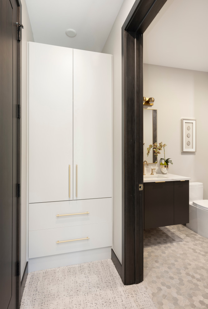 Cette image montre une armoire encastrée design neutre avec un placard à porte plane, des portes de placard grises, moquette et un sol blanc.