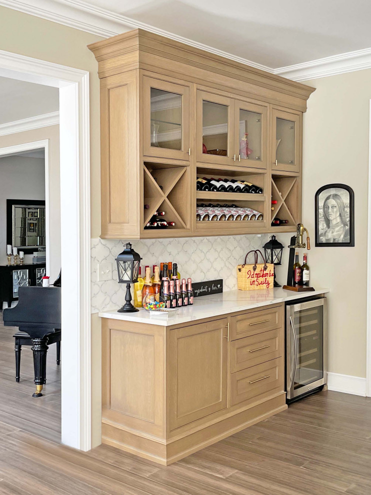 Large transitional u-shaped medium tone wood floor, brown floor and coffered ceiling eat-in kitchen photo in New York with a drop-in sink, shaker cabinets, white cabinets, quartz countertops, white backsplash, quartz backsplash, white appliances, an island and white countertops